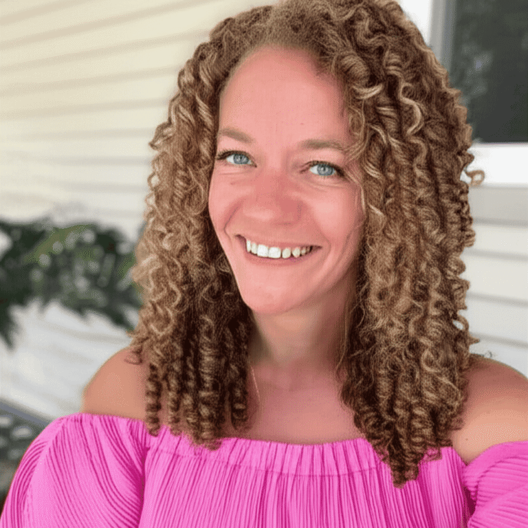 Danielle gray smiling at the camera, relaxed and wearing hot pink